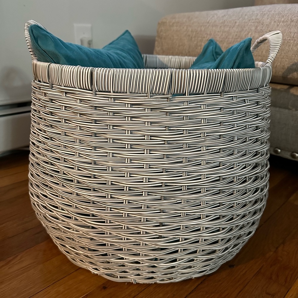 White and gray wicker basket with 3 throw pillows